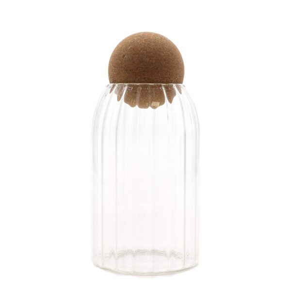 Borcan din sticlă cu capac bilă de plută, striat – 15 cm Borcan din sticlă transparentă cu striații fine și capac rotund din plută așezat pe un fundal luminos.